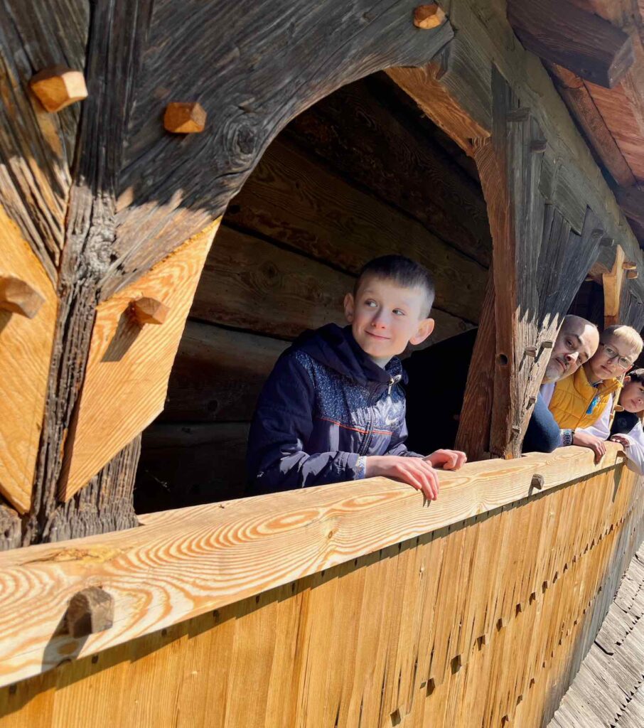Les enfants font découvrir à Pascal Falcone l'église en bois de leur commune.